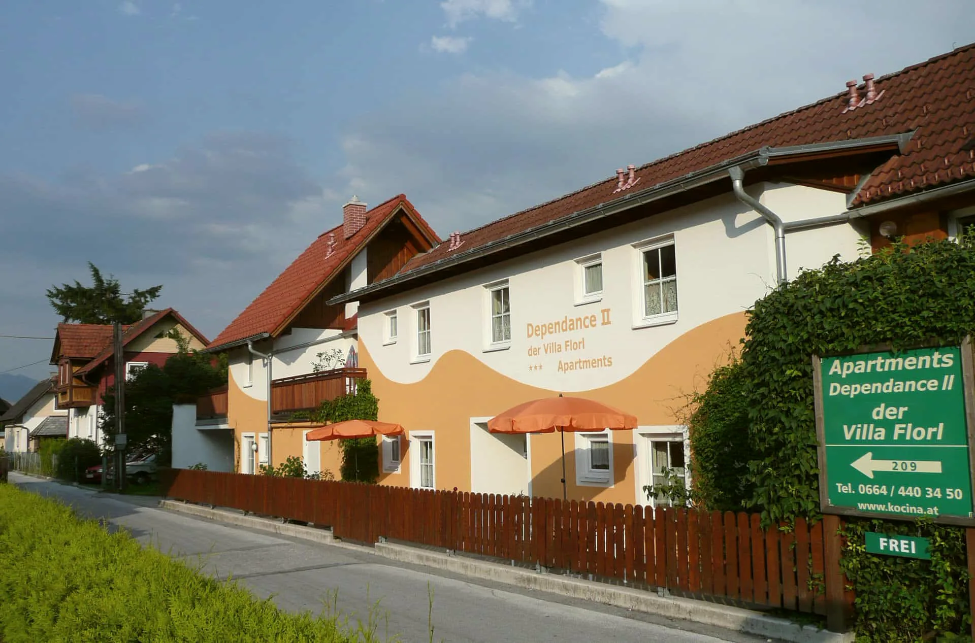 Dependance II der Villa Florl mit Sonnenschirmen und Holzzaun